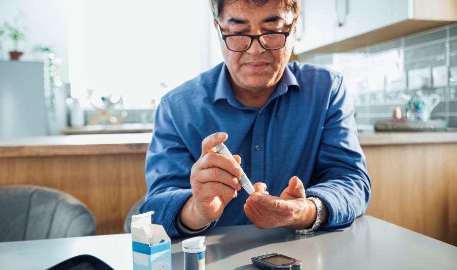 Man using a glucose meter to test his blood sugar levels