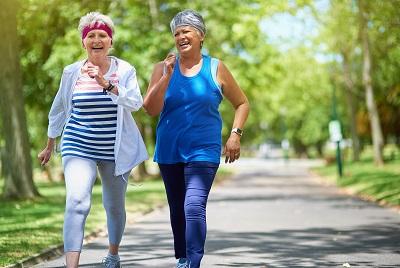 Two middle aged women laughing and walking