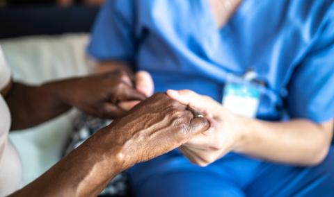 Nurse holding hands of elder Black woman