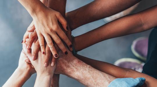 Stack of hands showing unity