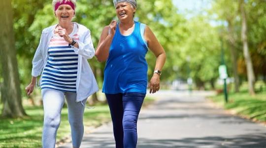 Two middle aged women laughing and walking