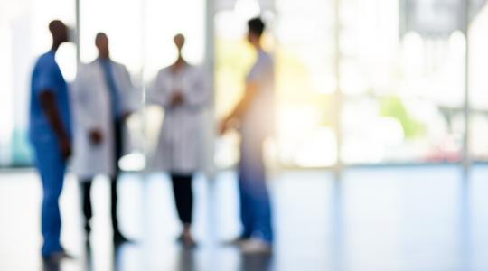 blurred image of doctors and nurses talking