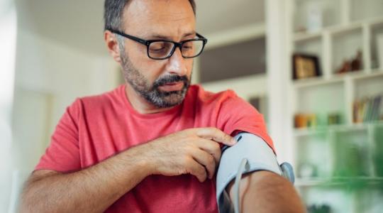 Man testing blood pressure at home