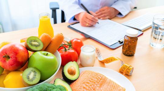 Dietician at desk with healthy foods