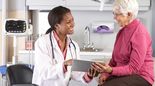Doctor speaks with patient in exam room